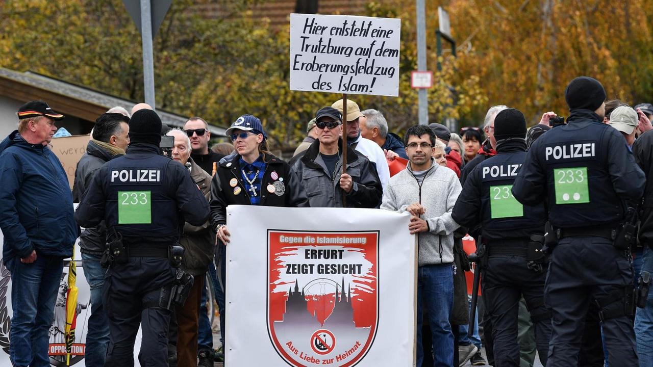 Erfurter demonstrieren während der Grundsteinlegung für eine neue Moschee mit einem Plakat mit der Aufschrift "Hier entsteht eine Trutzburg auf dem Eroberungsfeldzug des Islam!".
