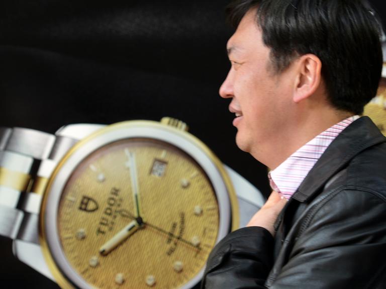 Ein Fußgänger läuft vorbei an einem luxuriösen Uhren-Shop im größten Einkaufsviertel Shanghais in China (aufgenommen 2013).