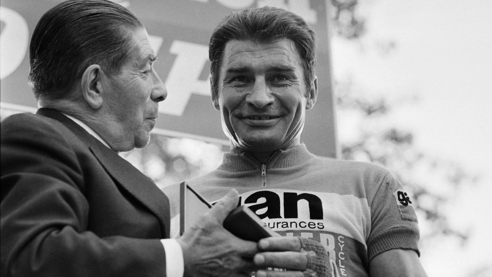 Der französische Radrennfahrer Raymond Poulidor nimmt eine Medaille entgegen.