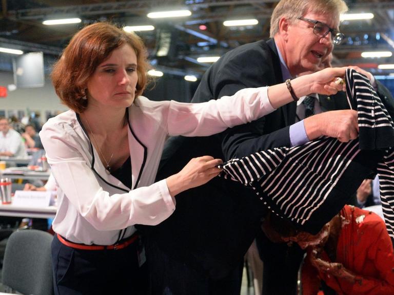 Nach einem Angriff mit einer Sahnetorte auf Sahra Wagenknecht bedecken die Parteisorsitzende Katja Kipping und der Fraktionsvorsitzende Dietmar Bartsch Sahra Wagenknecht mit einer Jacke