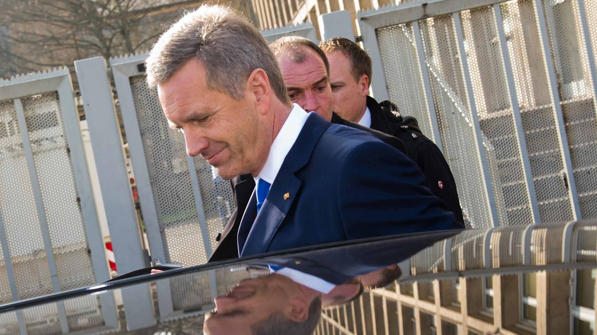 Ex-Bundespräsident Christian Wulff (M.) verlässt am 27.02.2014 nach der Urteilsverkündung das Landgericht in Hannover und steigt in ein Auto ein.