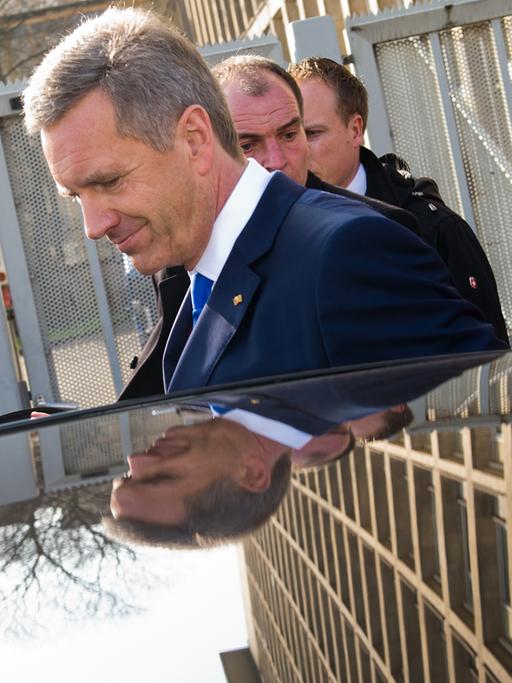 Ex-Bundespräsident Christian Wulff (M.) verlässt am 27.02.2014 nach der Urteilsverkündung das Landgericht in Hannover und steigt in ein Auto ein.