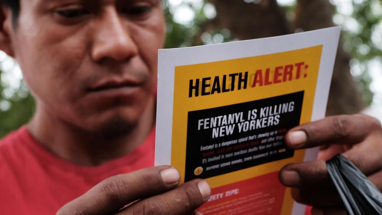 Ein Mann hält einen Warnhinweis zur Droge Fentanyl in der Hand – ein rein synthetisches Opioid, in der Wirkung mindestens hundert Mal stärker als das semisynthetische Oxycodon, aufgenommen im New York am 8. August 2017