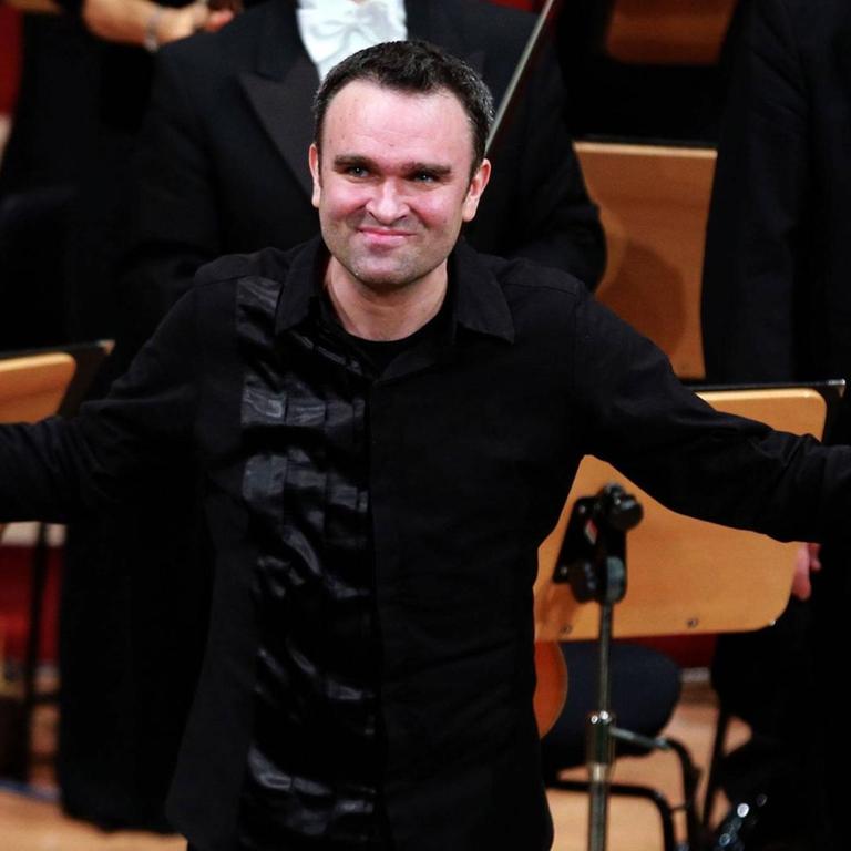 Der Klarinettist Jörg Widmann steht beim Musikfestival Heidelberger Frühling im April 2016 auf der Bühne. In der rechten Hand hält er eine Klarinette und er bedankt sich beim Publikum. 