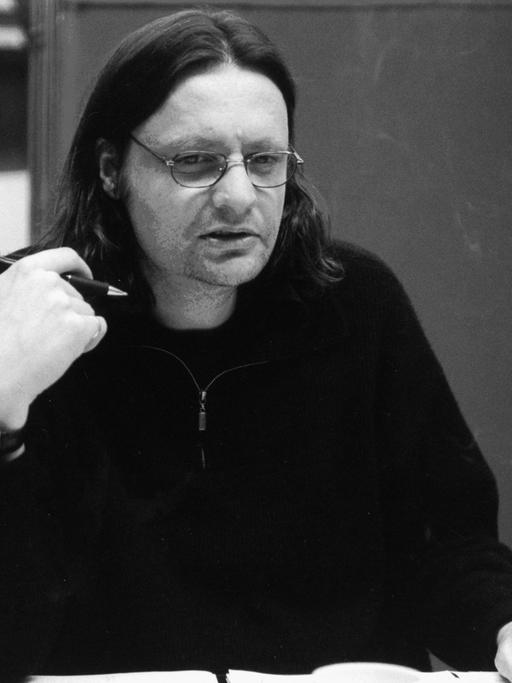 Eine schwarz-weiß Aufnahme des Regisseurs Ulrich Lampen im Studio. 