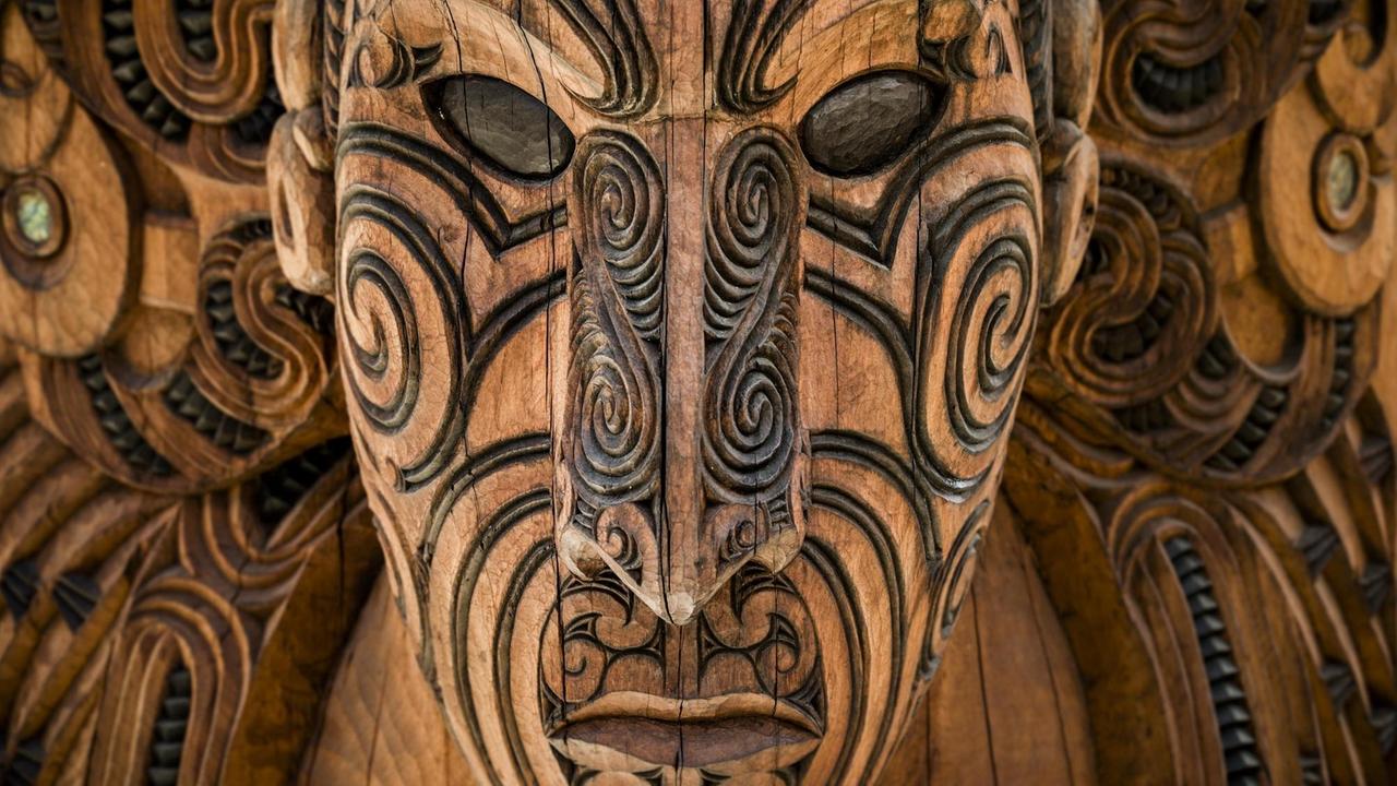 Eine geschnitzte Maske der Maori blickt dem Betrachter entgegen.