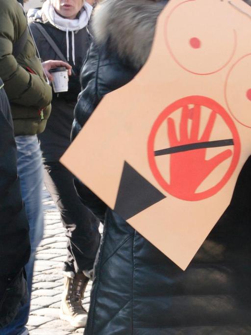 In Dresden auf dem Neumarkt trägt eine Frau auf einer Veranstaltung auf dem Ruecken ein symbolisches Bild gegen sexuelle Belästigung oder sexuelle Uebergriffe