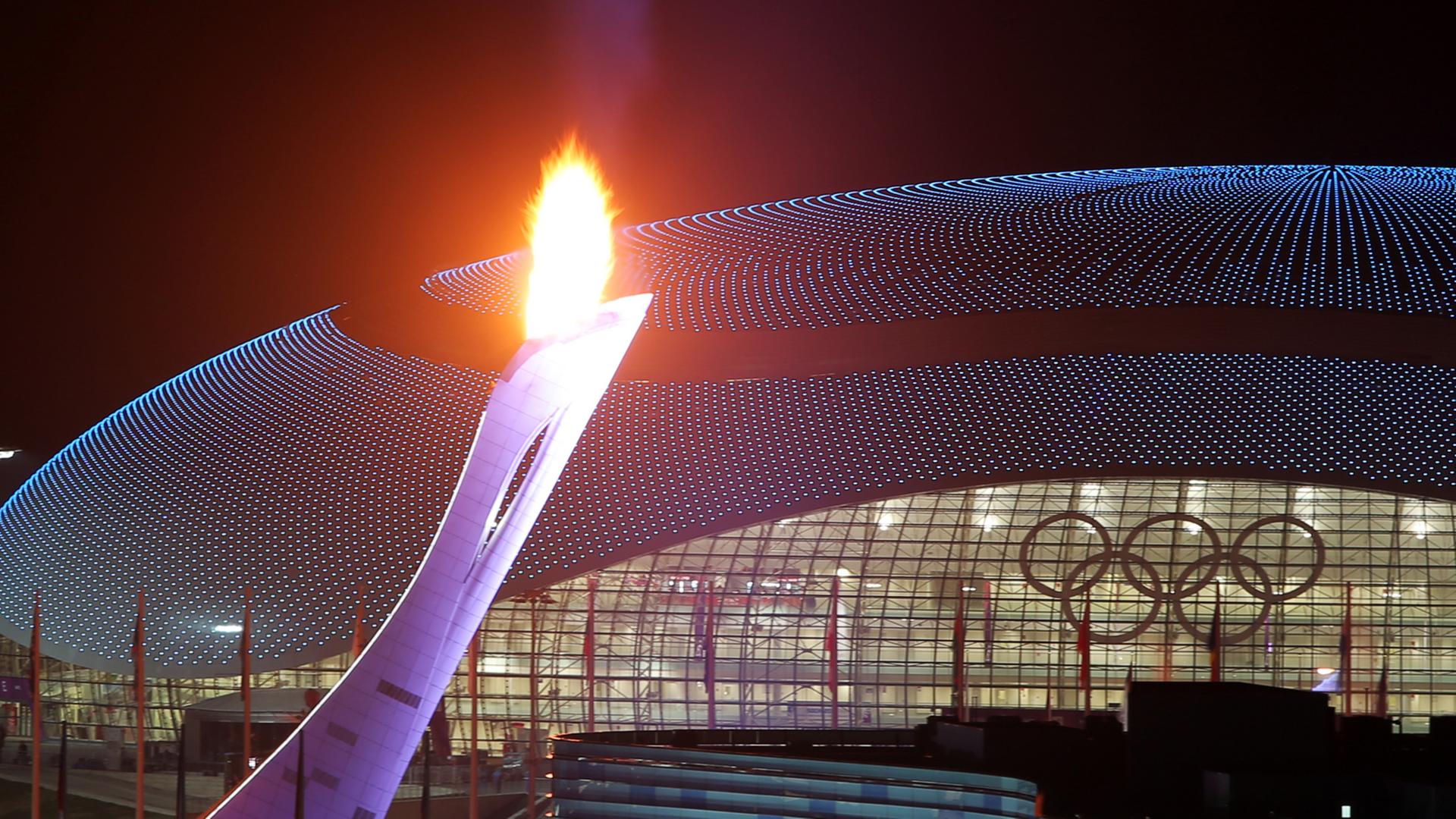In Sotschi sind das Olympische Feuer, das Einhockeystadion und die Eislauf-Arena zu sehen.