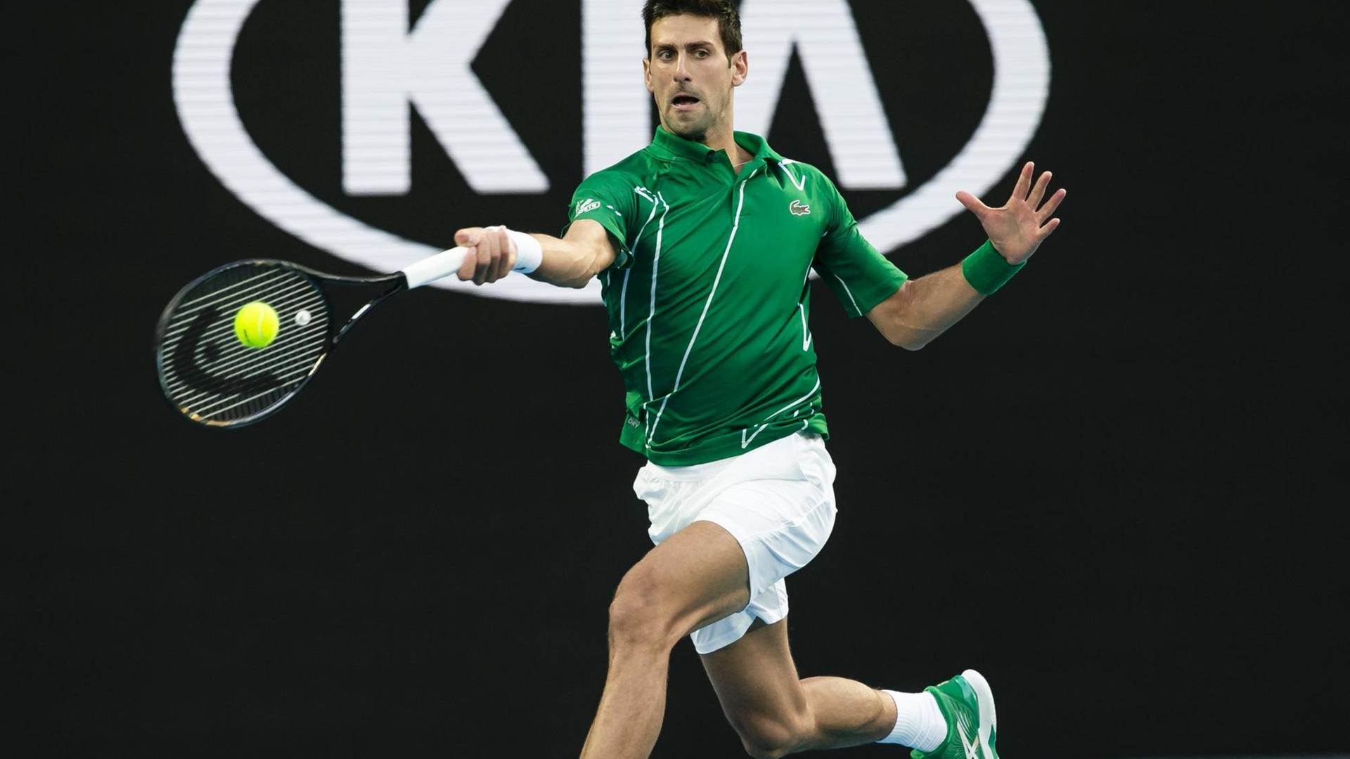 Novak Djokovic schlägt einen Tennis-Ball.