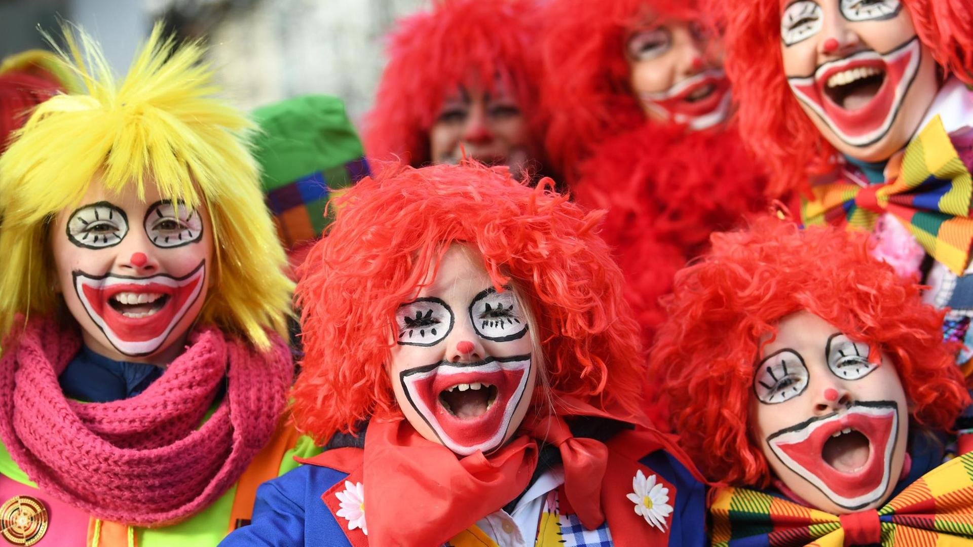 12.02.2018, Nordrhein-Westfalen, Düsseldorf: Als Clowns geschminkte Karnevalisten nehmen an dem Rosenmontagszug teil.