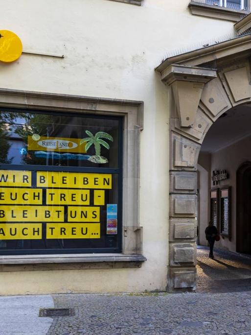 Am Fenster eines geschlossenen Reisebüros in Stuttgart steht: "Wir bleiben euch treu - bleibt uns auch treu".