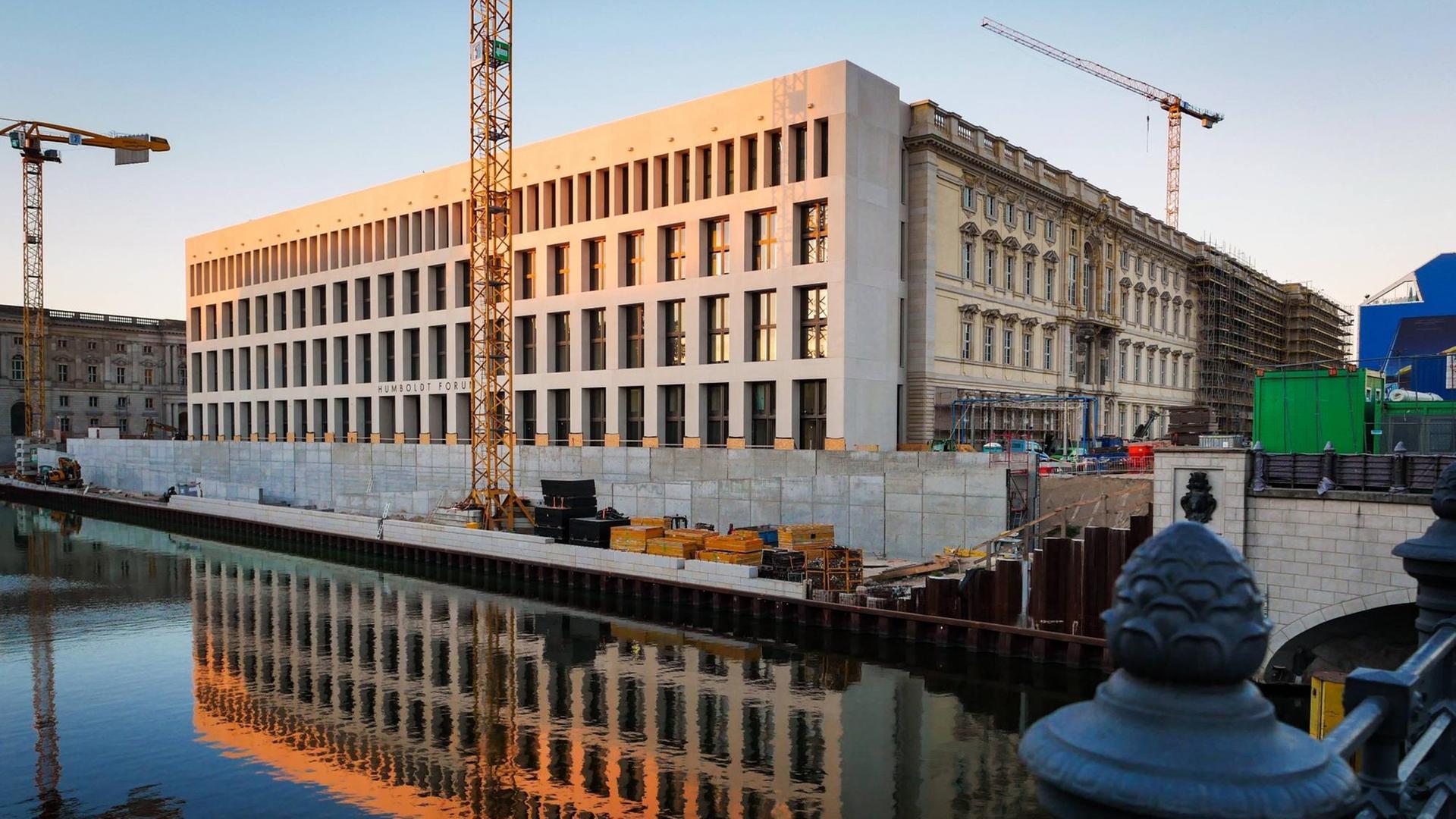 Das Gebäude des Humboldtforums im Bau, mit Kran davor, spiegelt sich im Wasser. Das Gebäude des Humboldtforums im Bau, mit Kran davor, spiegelt sich im Wasser.