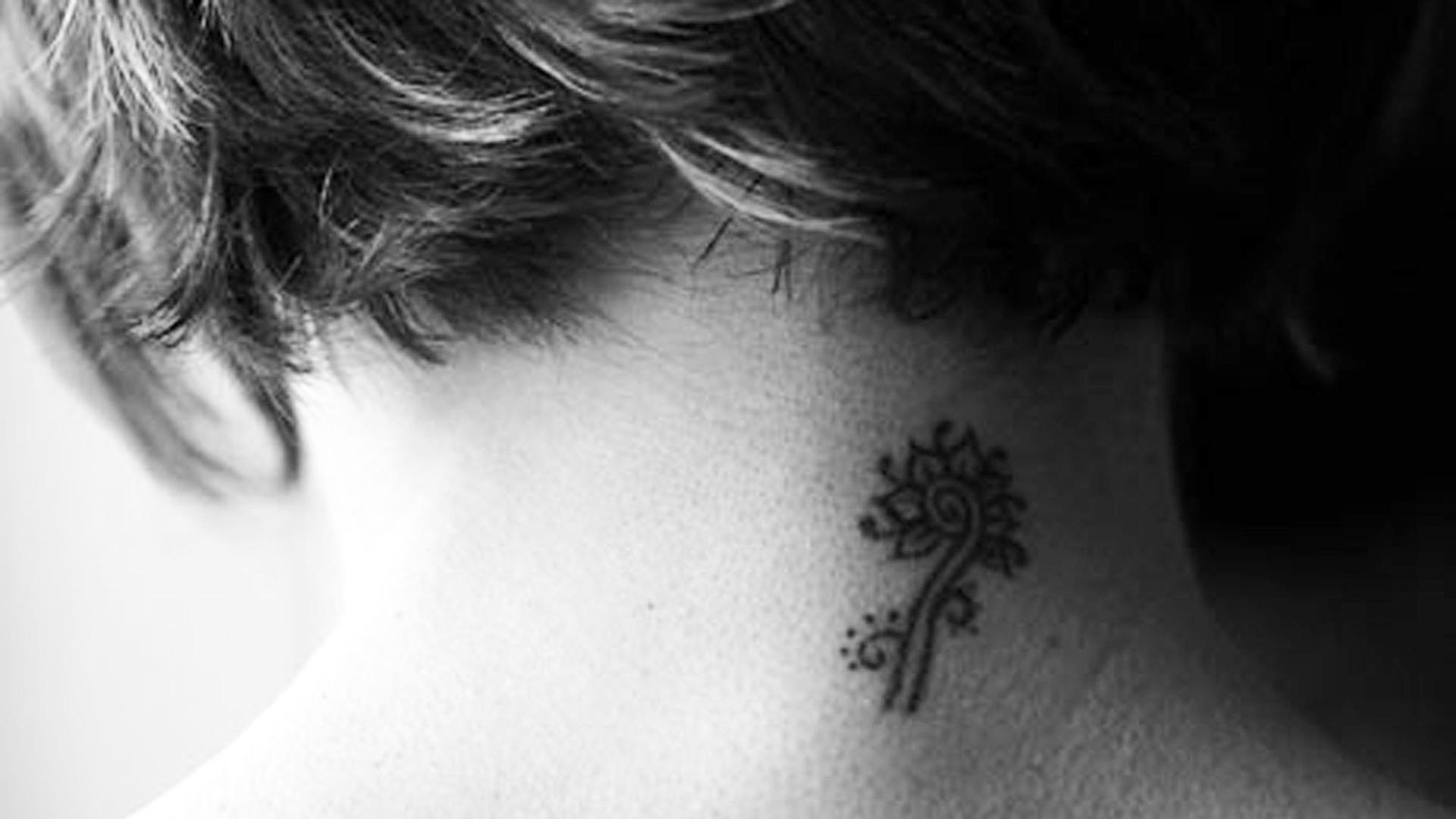 Ein Tattoo am Nacken einer Frau.