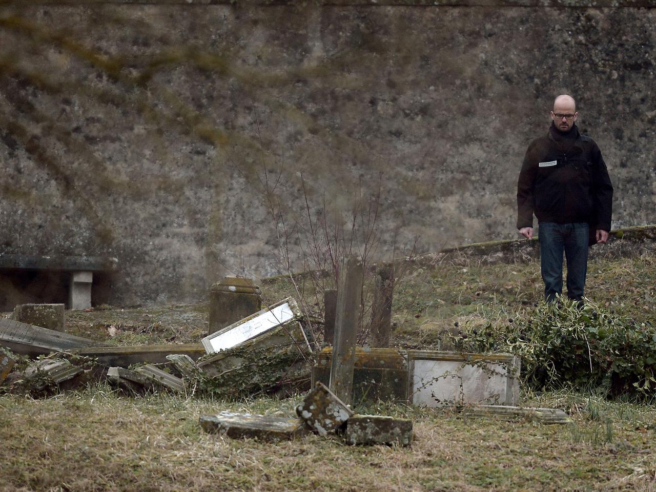 Ein Ermittler steht vor geschändeten Gräbern auf einem jüdischen Friedhof in ostfranzösischen Stadt Sarre-Union. 