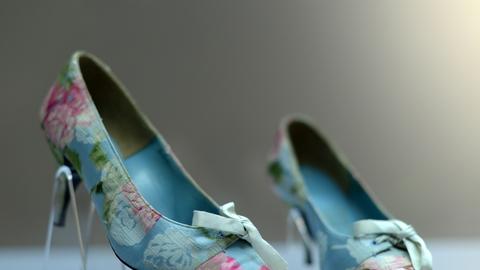 Spitze, mit hellblauem und rosa-farbenem Stoff bezogene Schuhe auf einem Pfennigabsatz von Roger Vivier stehen als Ausstellungsstücke in einer Vitrine im Offenbacher Deutschen Ledermuseum.