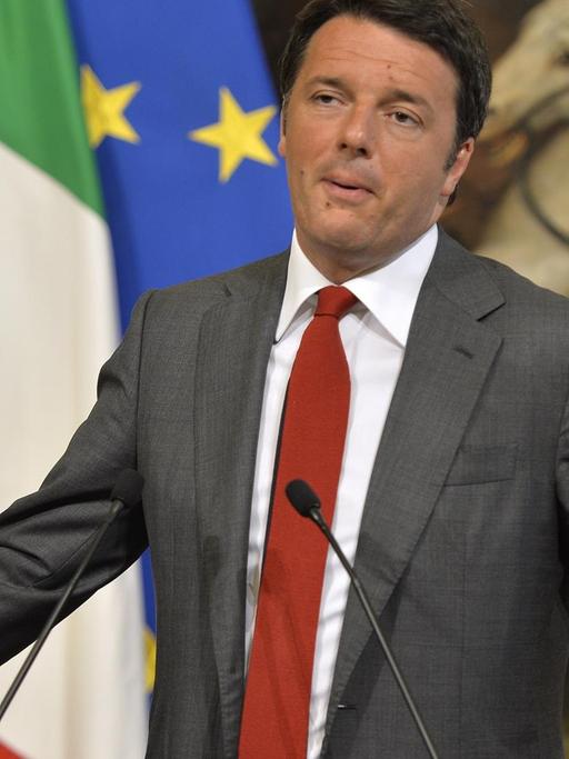 Renzi gestikuliert bei einer Pressekonferenz vor den Fahnen Italiens und Mexikos sowie einem Gemälde mit Reitern.