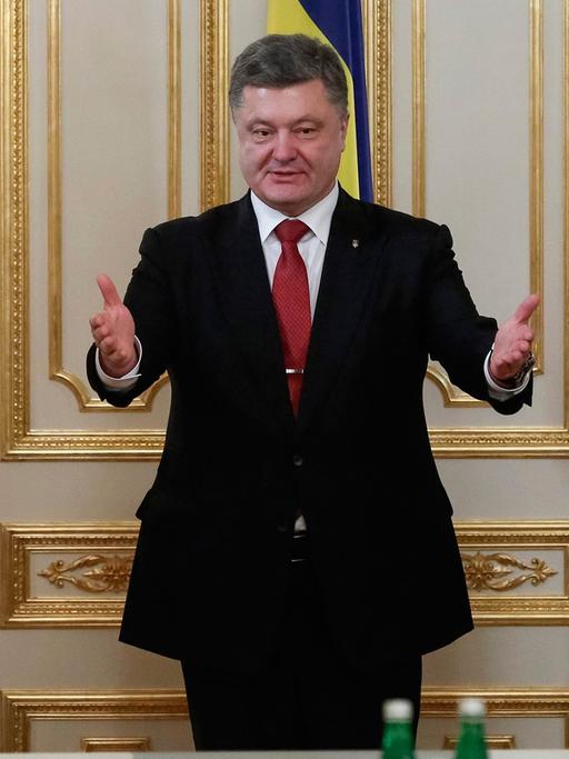 Bundeskanzlerin Angela Merkel (li.) und Frankreichs Präsident Francois Hollande (re.) stehen neben dem ukrainischen Staatsoberhaupt Petro Poroschenko, im Hintergrund sind die Flaggen der drei Länder zu sehen.