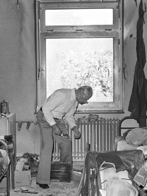 Ein Mann steht einer ausgebrannten Wohnung in einem Wohnheim für vietnamesische Flüchtlinge in Hamburg. In der Nacht zuvor wurde ein Brandanschlag mit drei Molotowcocktails begangen, bei dem zwei Vietnamesen ermordet wurden.