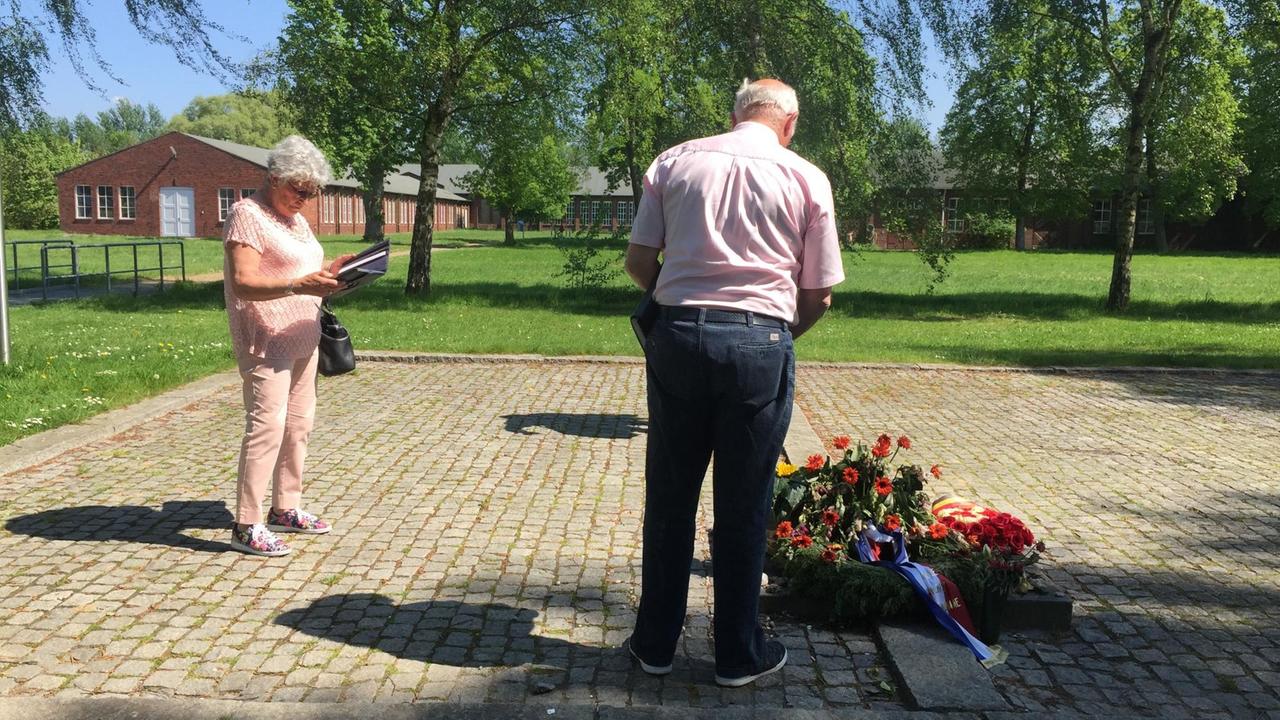 Der Niederländer Joost de Snoo und seine Frau Trus de Snoo legen auf dem Gelände des Konzentrationslagers Neuengamme Blumen nieder.