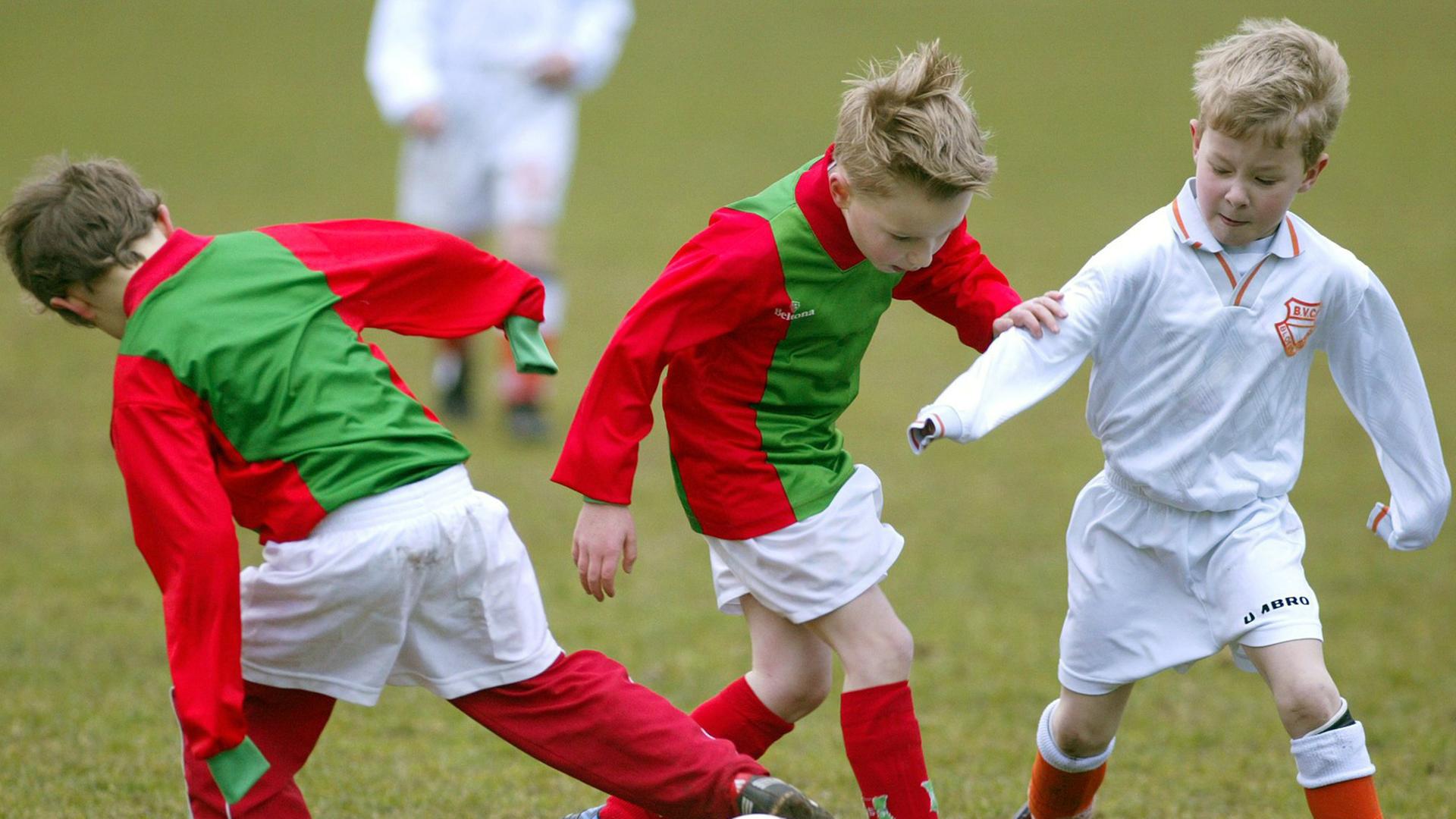 Kinder spielen Fußball. 