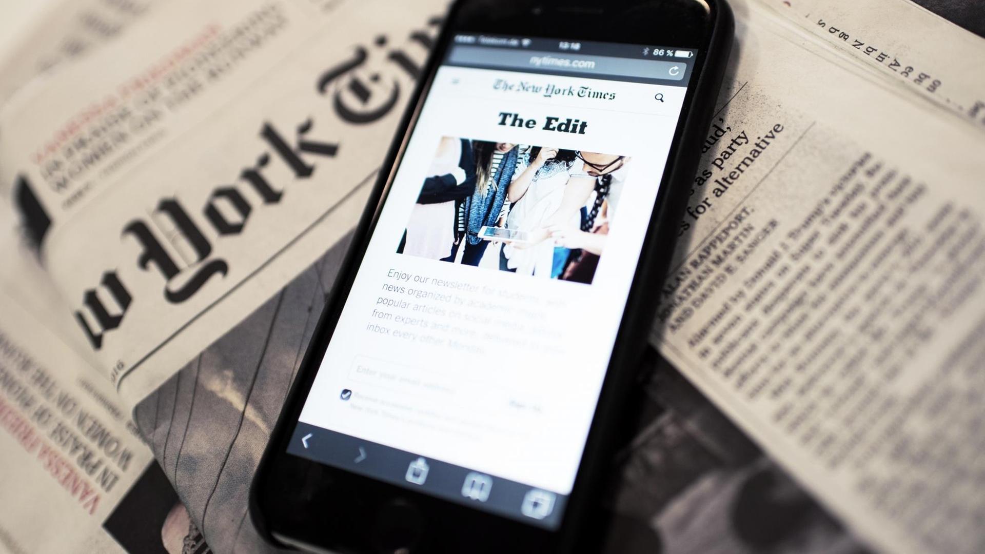 Ein Smartphone liegt auf einer Ausgabe der "New York Times"