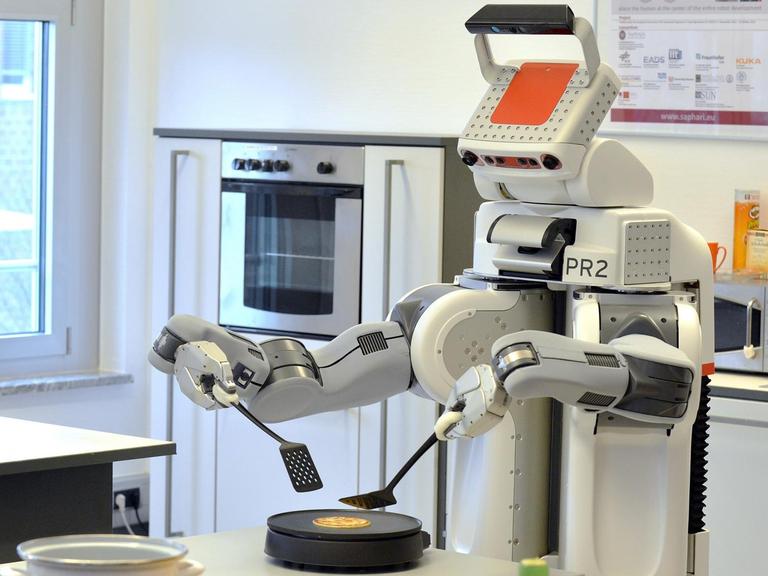 Der Roboter «PR2» dreht am 27.02.2013 in einer Laborküche des Institute for Artificial Intelligence (IAI) am Technologie-Zentrum Informatik (TZI) der Universität Bremen einen Pfannkuchen um. Der Roboter kann experimentell selbstständig Aufgaben im Haushalt übernehmen und ist Teil eines europaweiten Projekts. Foto: Michael Bahlo dpa/lni |