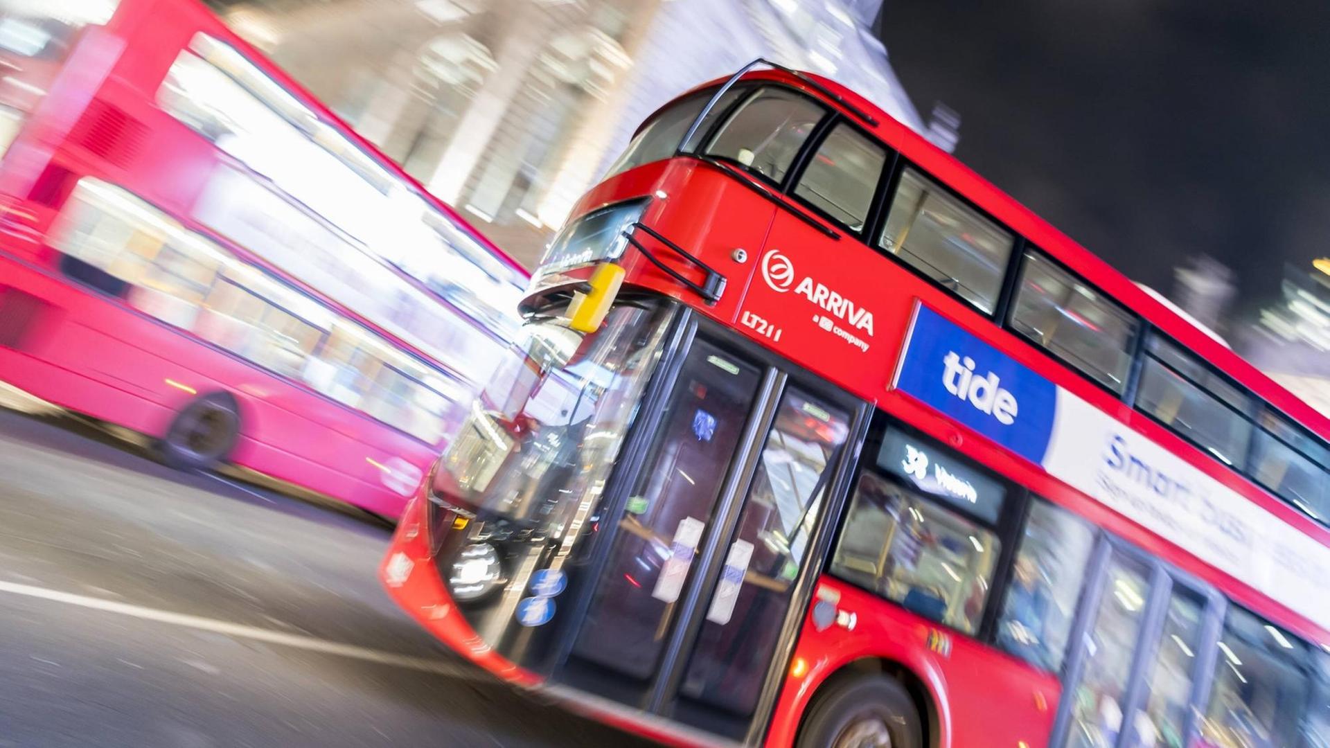 Ein roter Bus fährt nachts durch die britische Hauptstadt London.