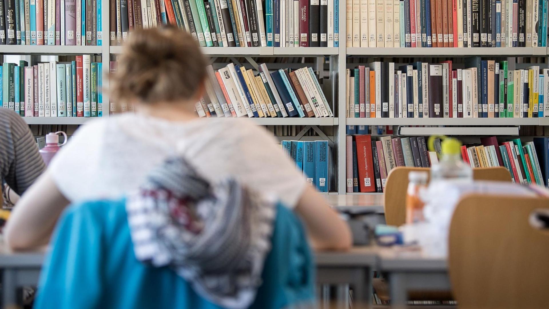 Eine Frau lernt in der Universitätsbibliothek Tübingen.
