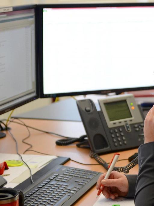 Eine Sachbearbeiterin telefoniert in ihrem Büro.
