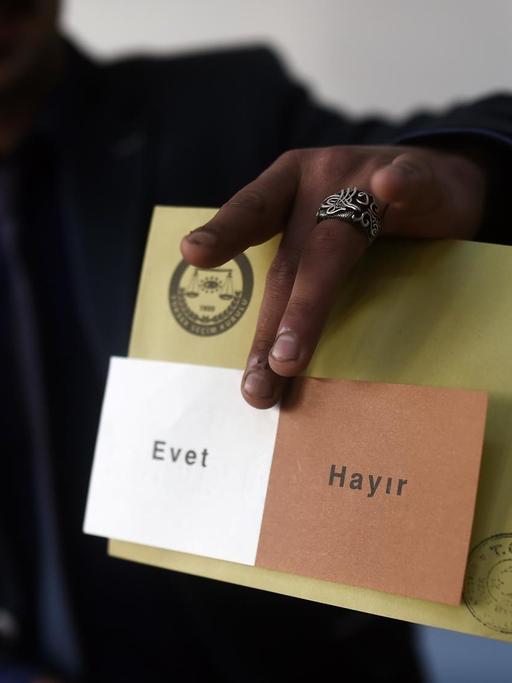 Ein Mann zeigt einen Stimmzettel mit der Aufschrift "Evet" (ja) und "Hayir" (nein).