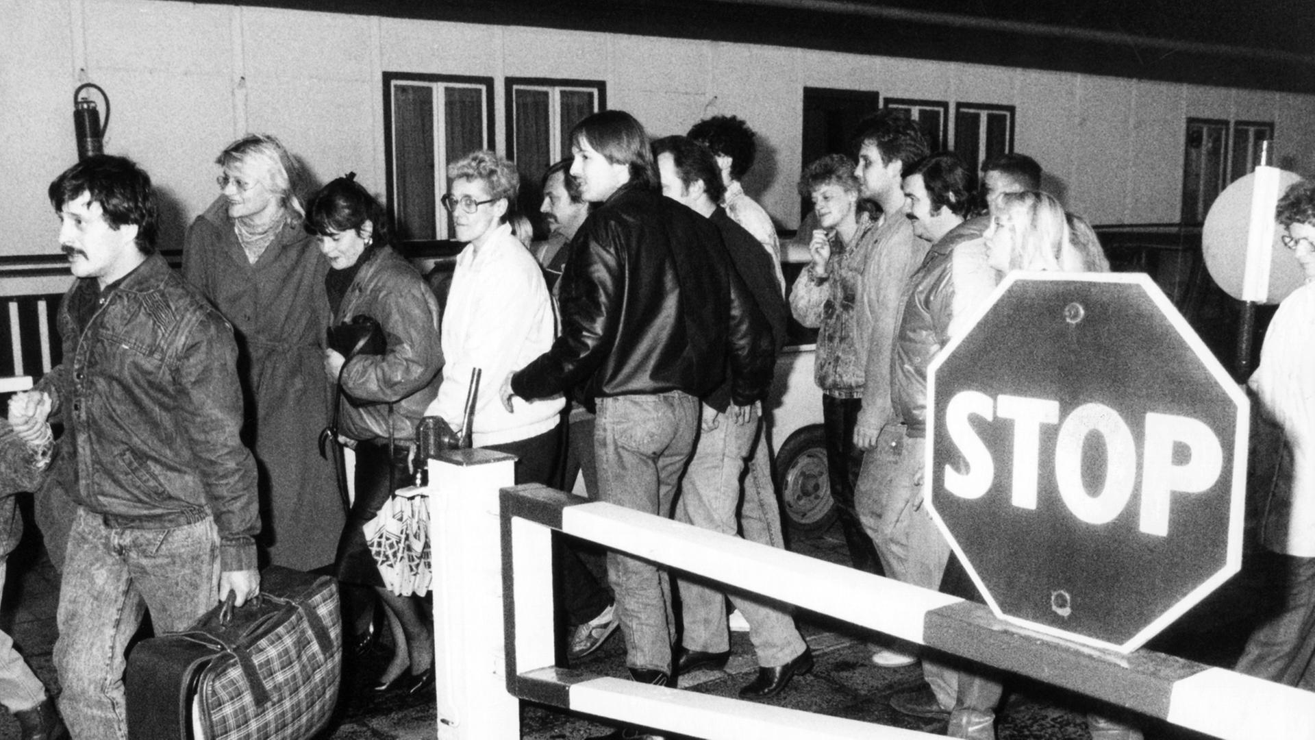 In der Nacht vom 9. auf den 10. November passieren diese Ost-Berliner vor Ihrer Einreise nach West-Berlin ein Grenzhäuschen. Nach der Bekanntgabe einer neuen großzügigen Reiseregelung für DDR-Bürger auf einer Pressekonferenz der DDR-Regierung am 09.11.1989 in Ost-Berlin fiel die innerdeutsche Grenze.