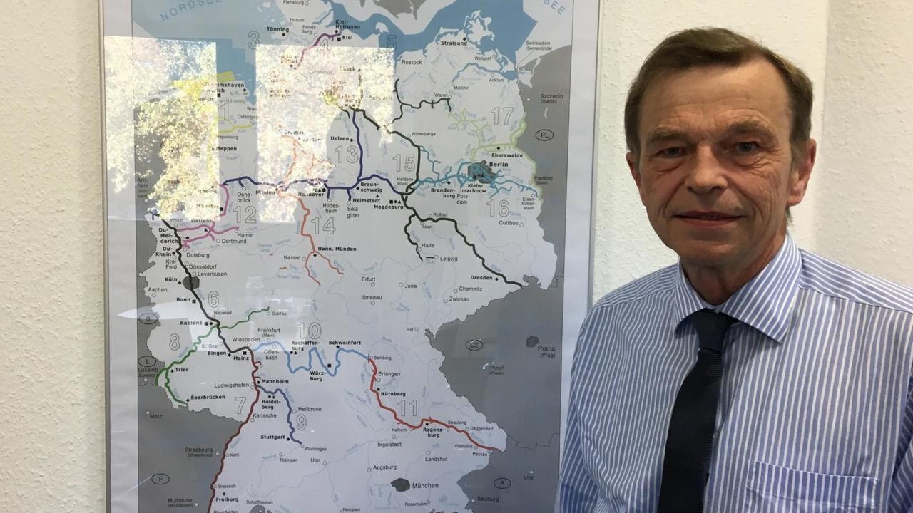 Das Foto zeigt den Bauingenieur Hans-Heinrich Witte, Präsident der Generaldirektion Wasserstraßen und Schifffahrt, vor einer Gewässerkarte.