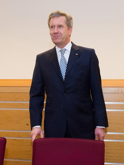 Christian Wulff im Gerichtssaal in Hannover. Er steht hinter einem Stuhl.