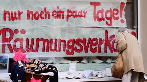 "nur noch ein paar Tage!" und "Raeumungsverkauf" steht im Schaufenster eines kleinen Schuhladens, der in der Corona-Pandemie schliessen muss.
