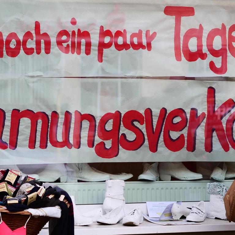"nur noch ein paar Tage!" und "Raeumungsverkauf" steht im Schaufenster eines kleinen Schuhladens, der in der Corona-Pandemie schliessen muss.