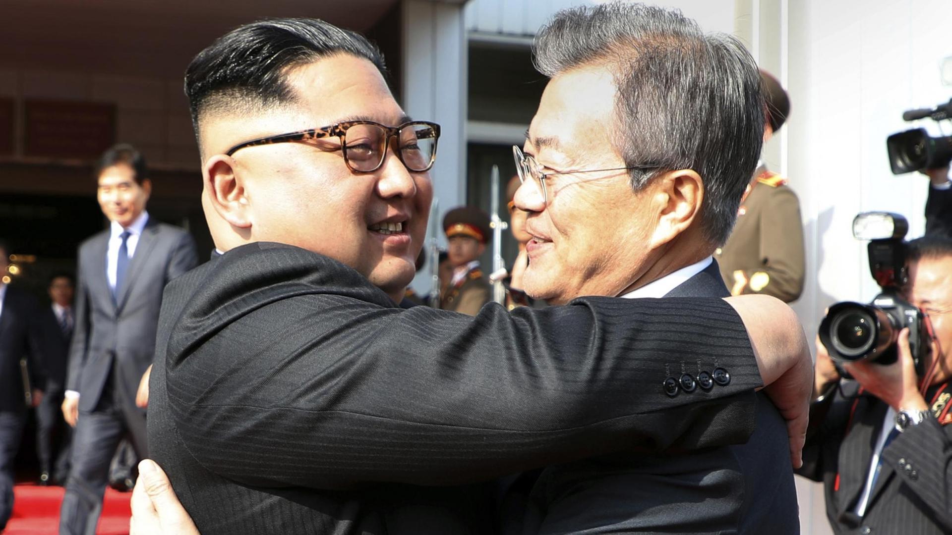Dieses vom Blauen Haus, dem südkoreanischen Präsidialamt zur Verfügung gestellte Foto zeigt Kim Jong Un (l), Machthaber in Nordkorea, und Moon Jae In, Präsident von Südkorea, die sich vor einem zweiten Treffen auf der nördlichen Seite der Grenze in der demilitarisierten Grenzstadt Panmunjom umarmen.