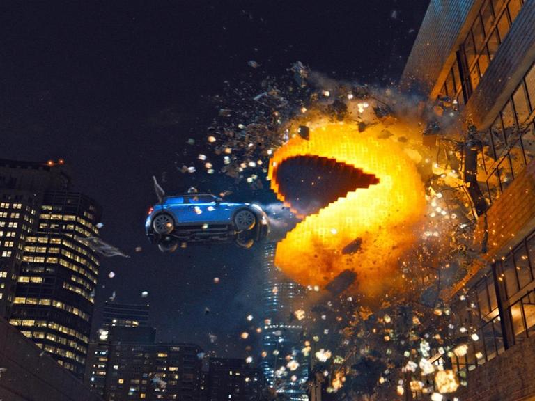 Szene aus dem Animationsfilm "Pixels": Ein animierte Pacman frisst ein fliegendes Auto