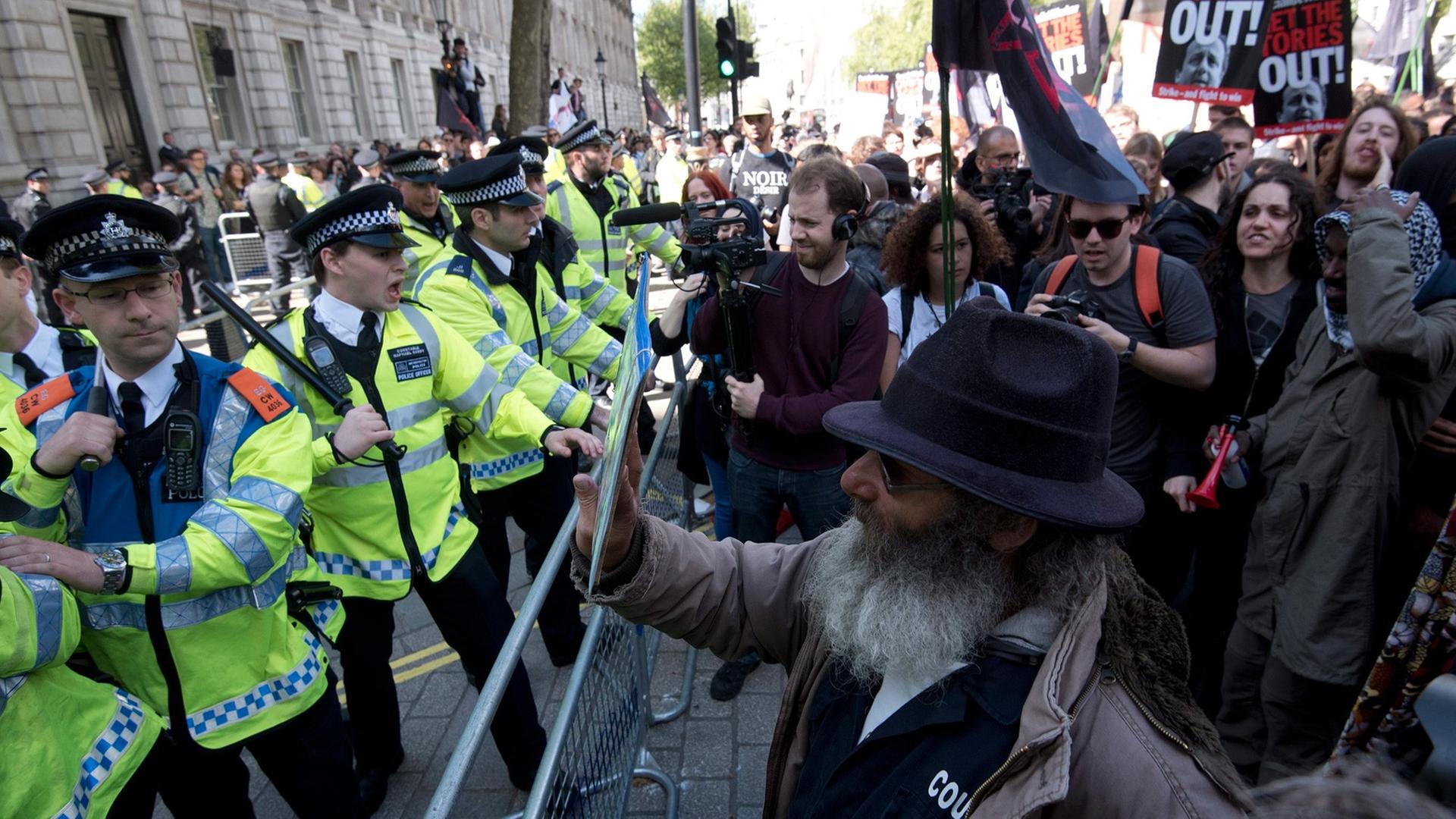 Eine Polizeiabsperrung gegen Demonstranten, die gegen die neue Regierung und deren Sparpolitik protestieren, in der Downing Street in London.