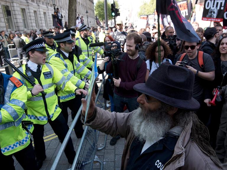 Eine Polizeiabsperrung gegen Demonstranten, die gegen die neue Regierung und deren Sparpolitik protestieren, in der Downing Street in London.