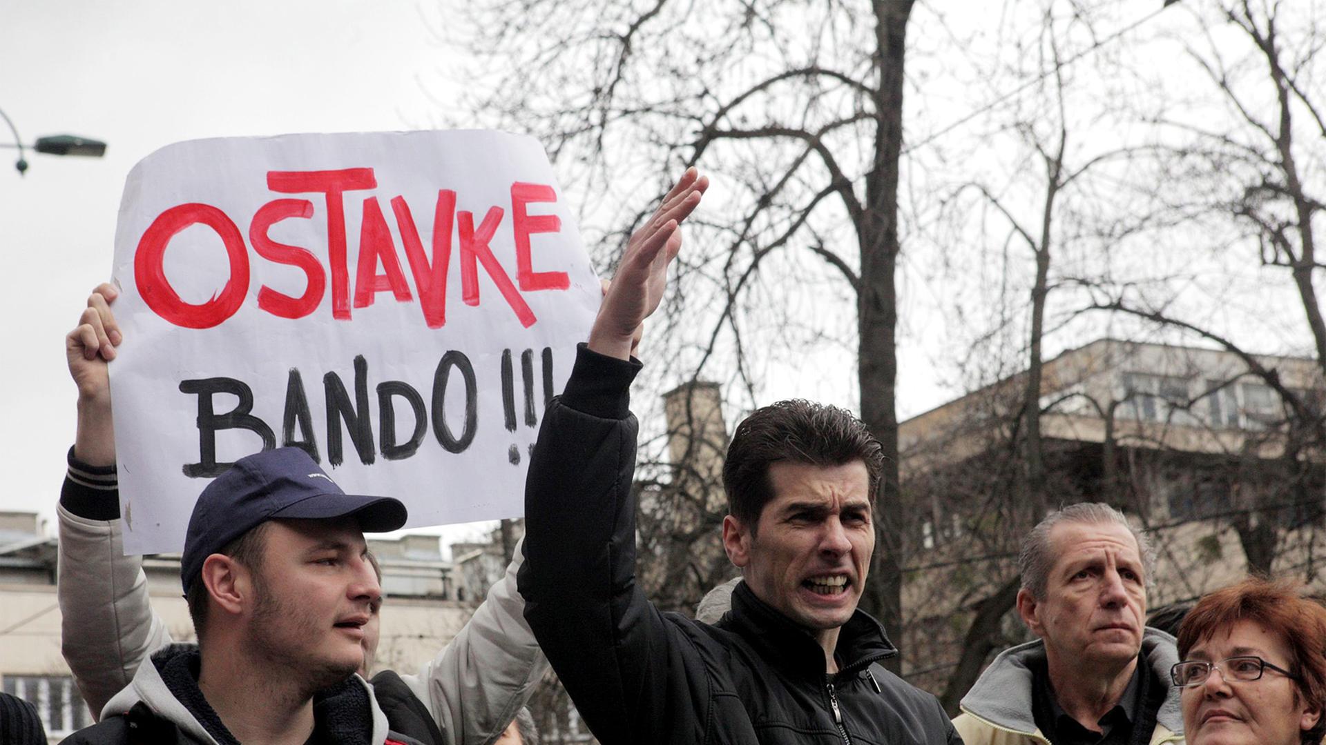 Demonstranten marschieren durch Sarajevo, mit einem Plakat fordern sie die Regierung zum Rücktritt auf.