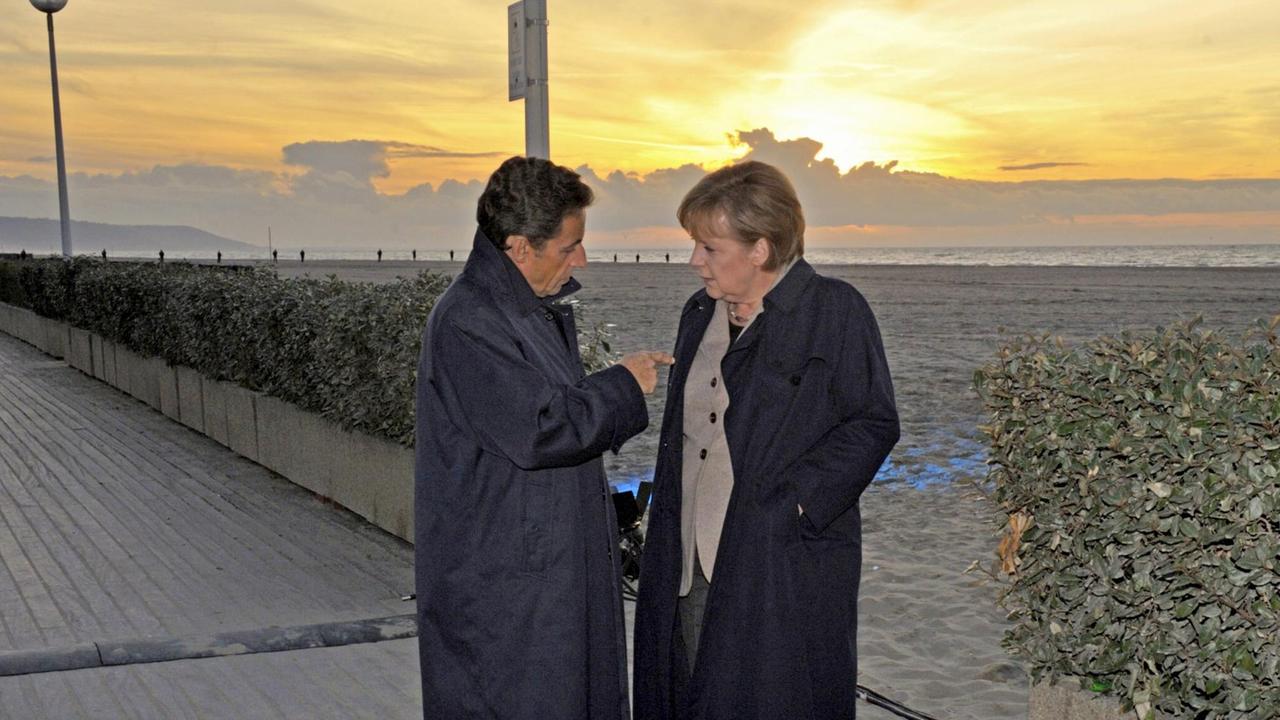 Der französische Präsident Nicolas Sarkozy und Bundeskanzlerin Angela Merkel gehen am 18.10.2010 an der Strandpromenade von Deauville spazieren. 