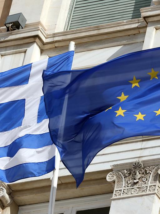 Die griechische und die europäische Flagge wehen vor dem Parlamentsgebäude in Athen.