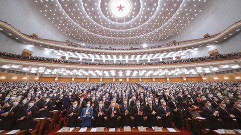 Beim 13. Nationale Volkskongress in China in Peking stehen die Teilnehmer auf und klatschen.