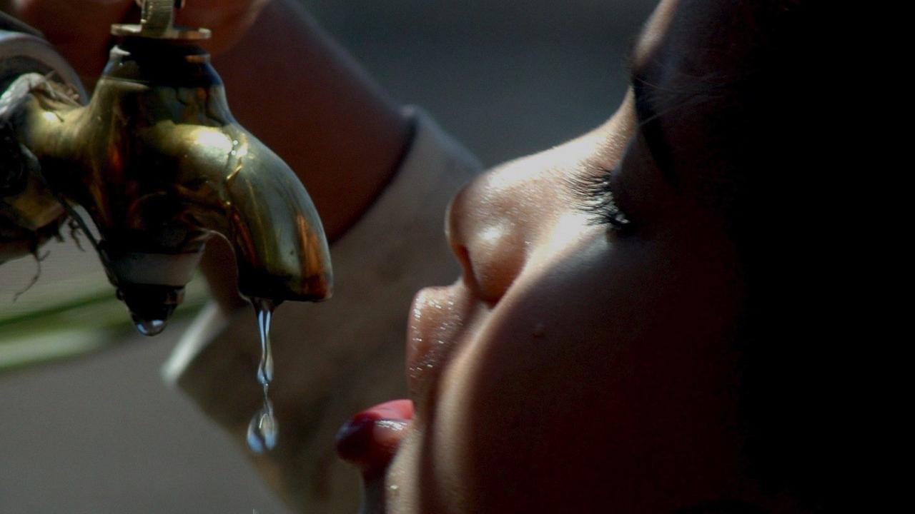 Ein jemenitisches Kind trinkt an einem Wasserhahn.