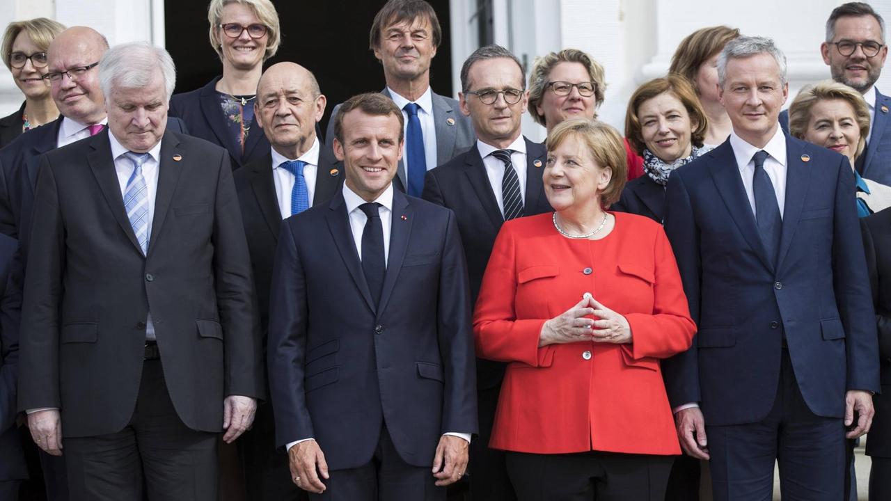 Bundeskanzlerin Angela Merkel, der französische Präsident Emmanuel Macron und Minister beider Regierungen posieren für ein Familiefoto im Schloss Meseberg in Brandenburg am 19. Juni 2018.