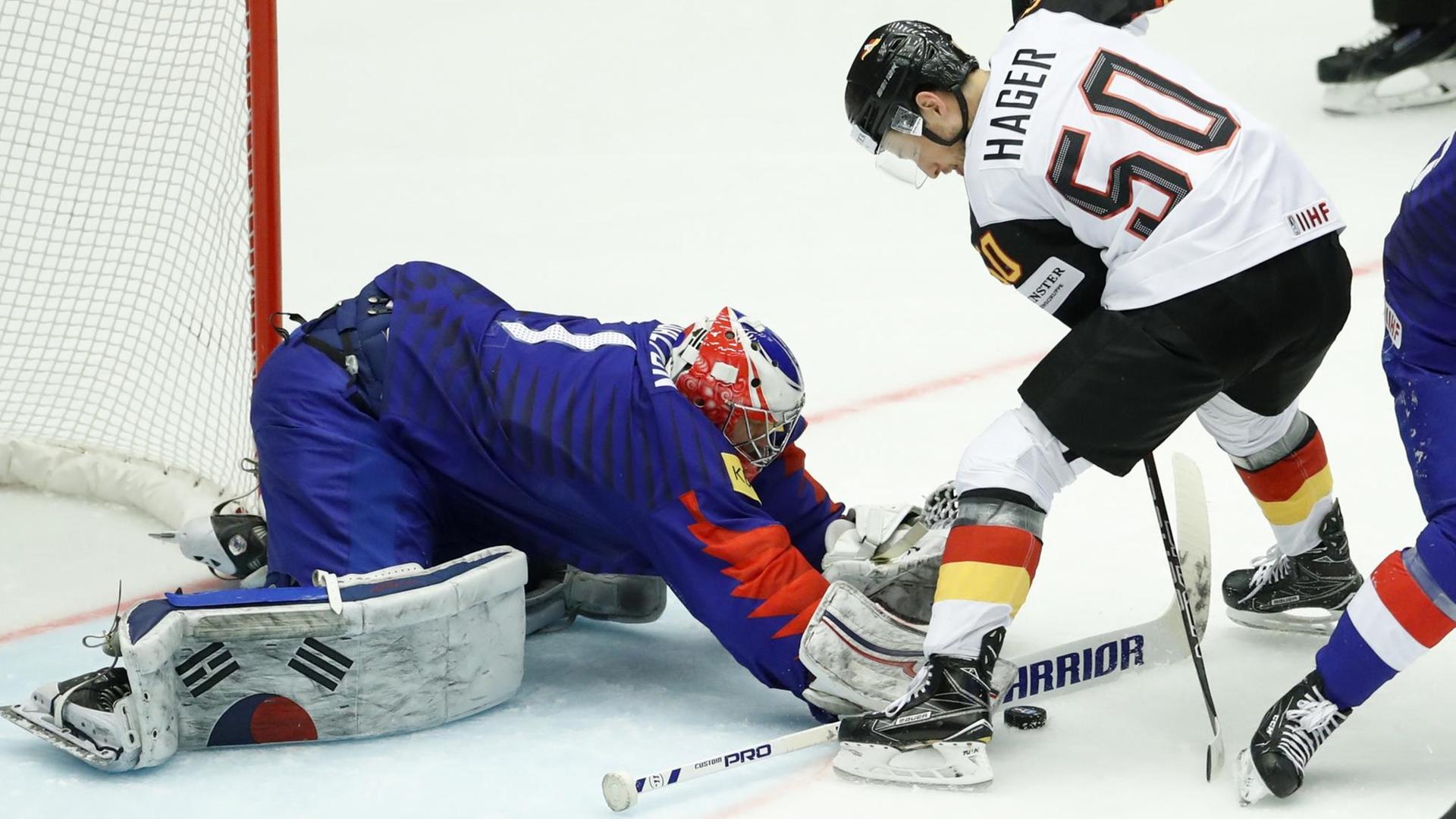 Der süd-koreanische Tor-Wart Matt Dalton wehrt den Schuss von Patrick Hager ab.