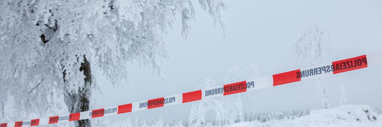 Nordrhein-Westfalen, Winterberg: Mit einem Absperrband der Polizei ist ein völlig zugeschneiter Parkplatz abgesperrt.


