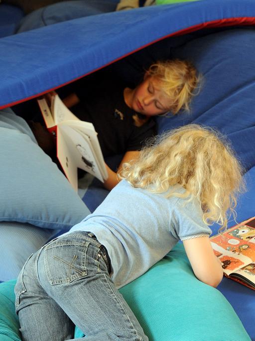 Lesende Kinder in einer Matratzenlandschaft auf der Kinder- und Jugendbuchmesse (KIBUM) in Oldenburg