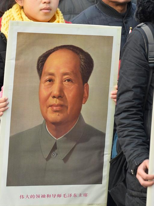 Studenten halten Poträts von Mao Zedong während einer Erinnerungsfeier zum 120. Geburtstag von Mao Zedong.