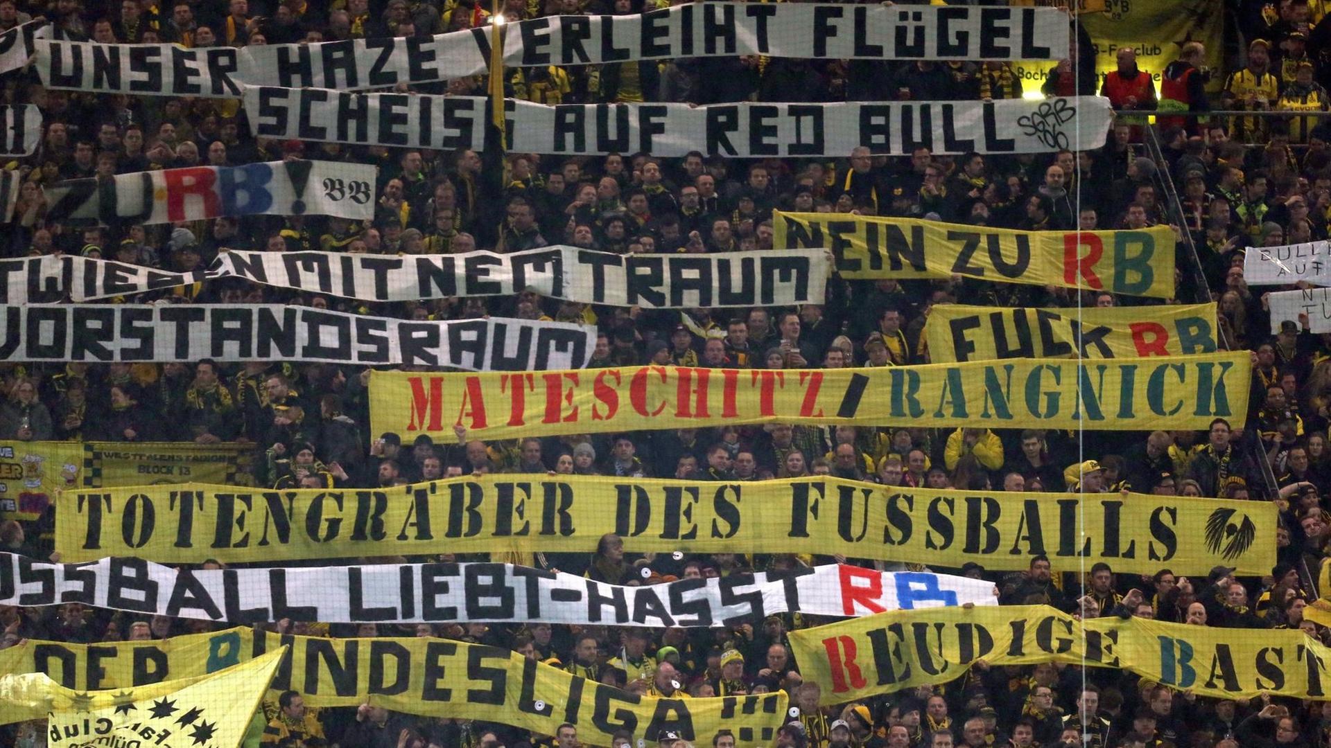 Dortmunder Fans halten Tarnsparente hoch mit Aufschriften wie "Totengräber des Fußballs" und "Scheiss auf Red Bull".